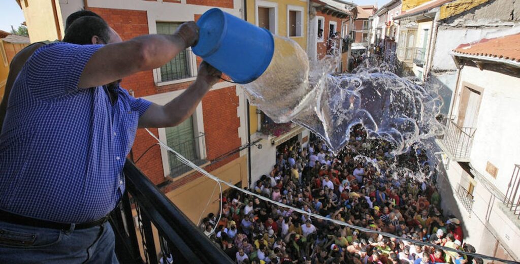 Un vecino de Peñafiel lanza agua al paso del Chúndara